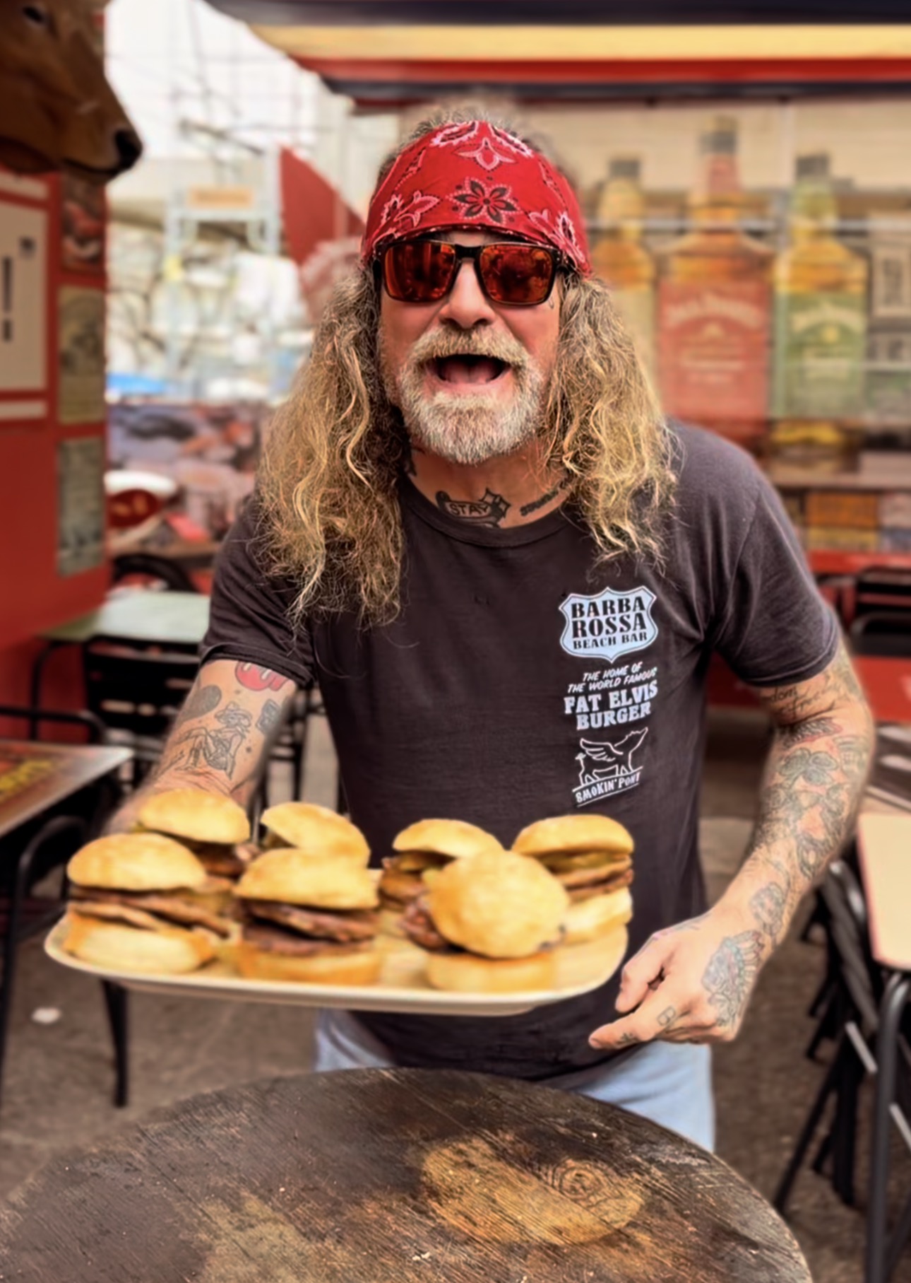 El dueño con una bandeja de burgers